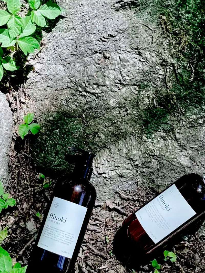 two hinoki bottles are set on rocks outdoor