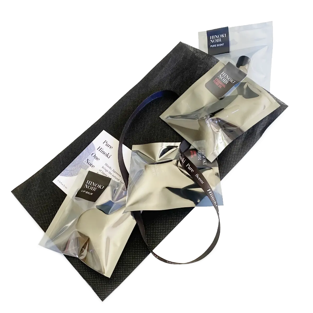Hinoki Noir & Noir Red Discovery Set, four minis in labeled silver pouches on a black gift bag with ribbon — TE PLUS TE