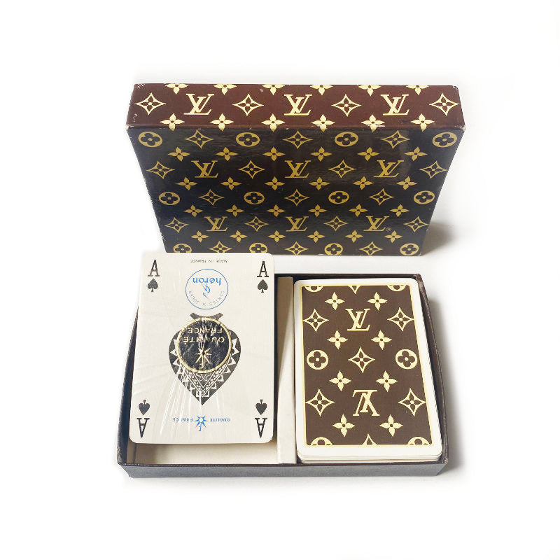 Playing cards with Louis Vuitton pattern in a branded box on a white background