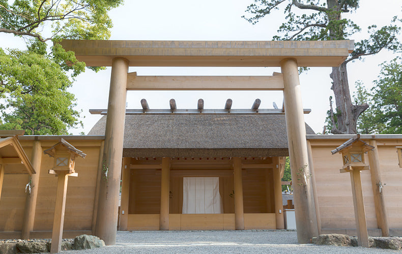 Traditional wooden Japanese building with torii gates in a park setting