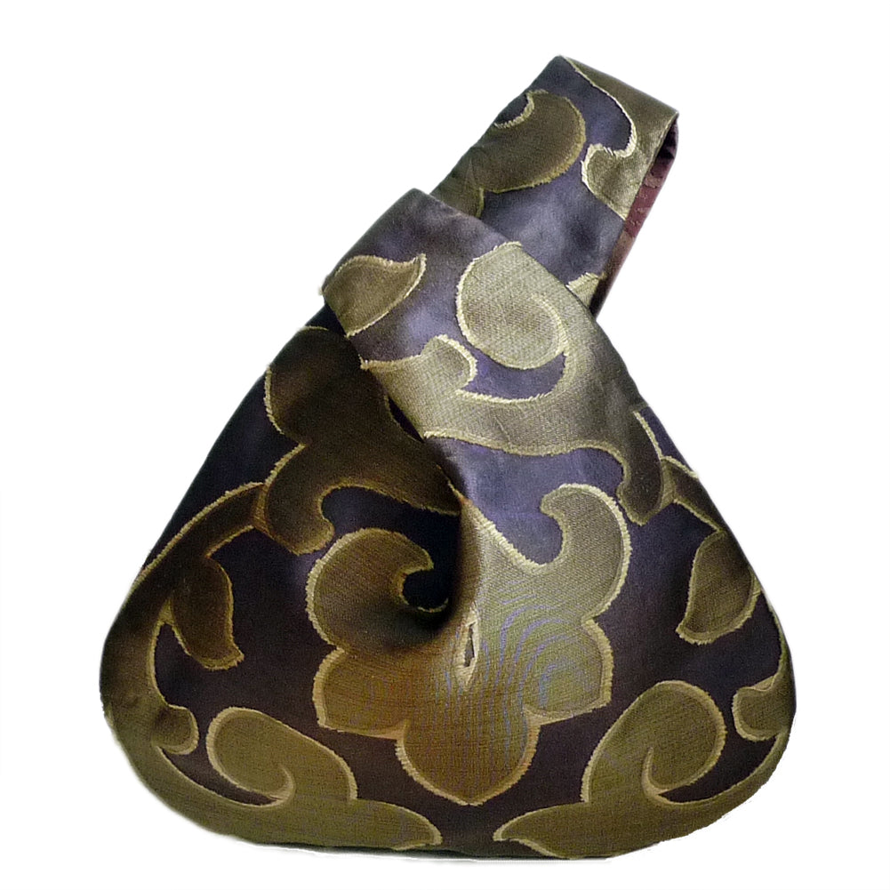 Front view of wristle bag .The simple shape of the bag perfectly balances and emphasizes the beautiful burnout sheer textile fabric. 