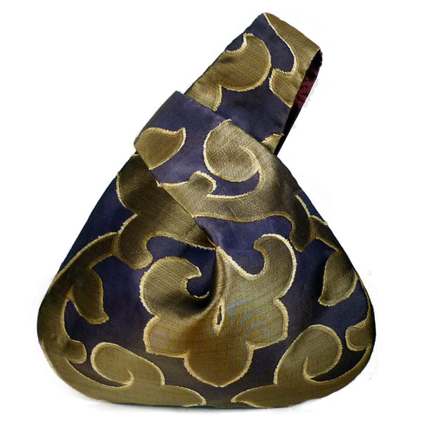 Front view of wristle bag .The simple shape of the bag perfectly balances and emphasizes the beautiful burnout sheer textile fabric. 